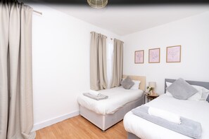 2 habitaciones, escritorio y tabla de planchar con plancha