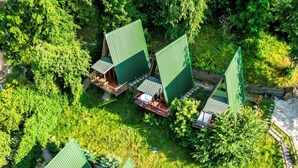 A resort with multiple green-roofed cabins, outdoor seating areas, and two swimming pools. - Natural Life Bungalows Sapanca (Sapanca)