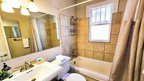 A bathroom with a sink, mirror, toilet, and bathtub. - The Terrace (Charlotte)