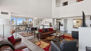 A spacious living area with a balcony, a dining area, and a kitchen.