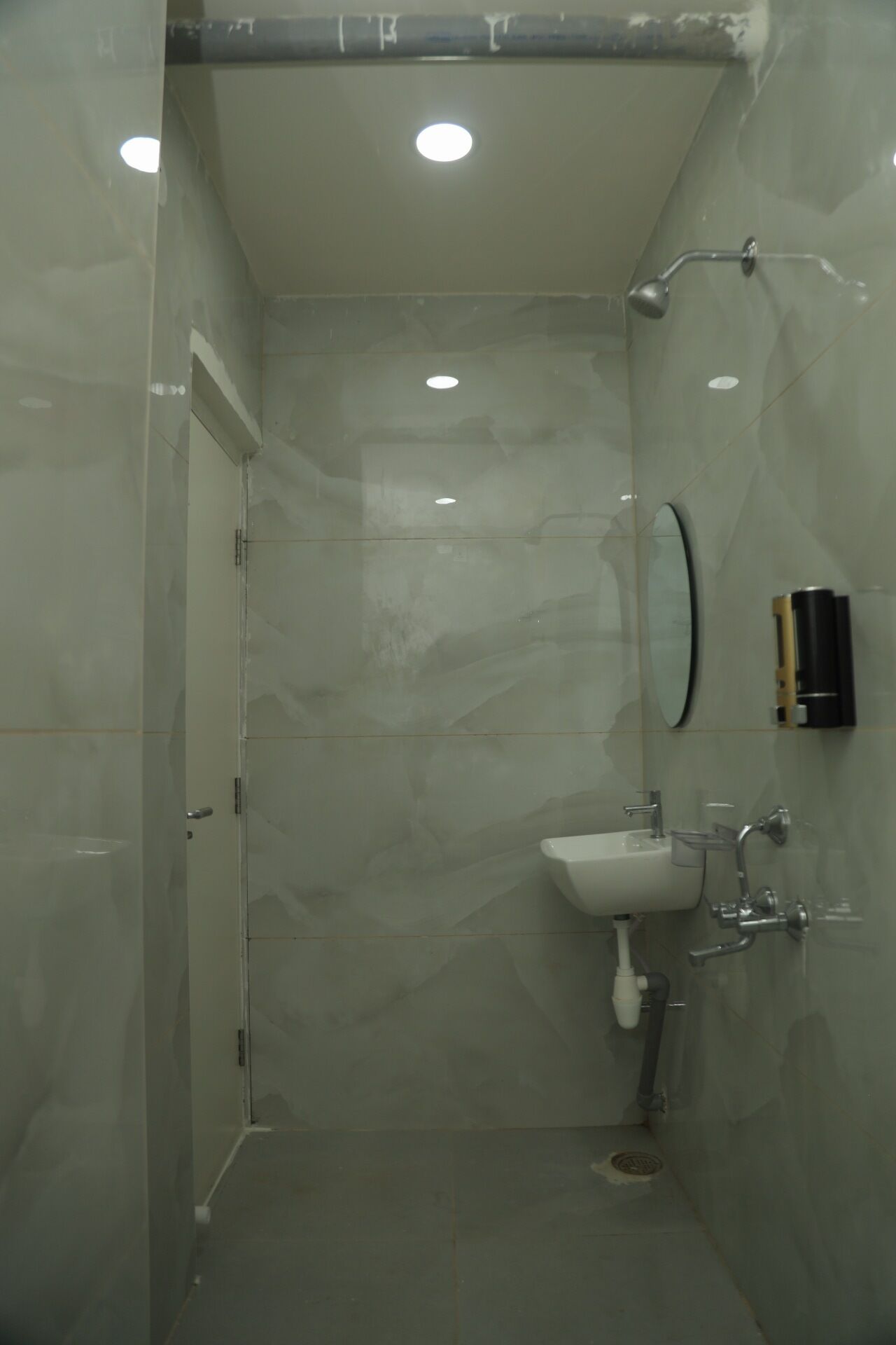 Une petite salle de bain moderne avec une douche à parois de verre, un lavabo blanc et un miroir.