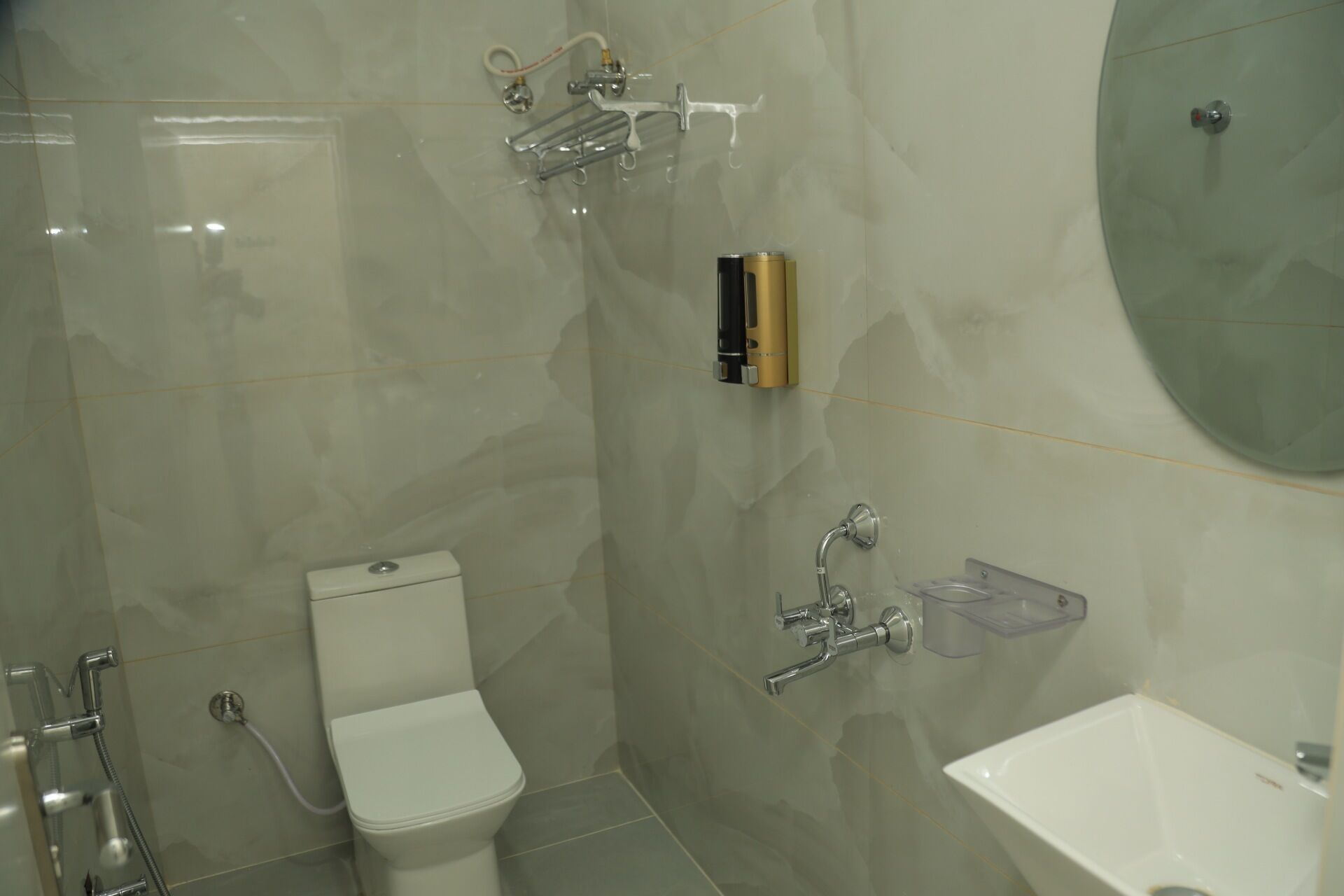 A modern bathroom with a toilet, shower, and sink.