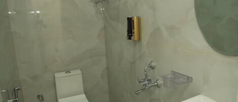 A modern bathroom with a toilet, shower, and sink.