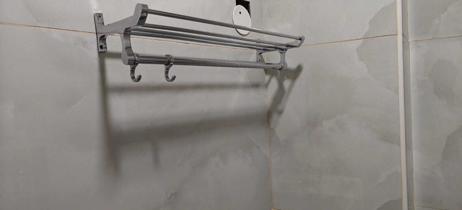 A metal towel rack mounted on a tiled wall.