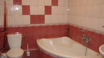 Un baño con inodoro, bañera y lavamanos.
