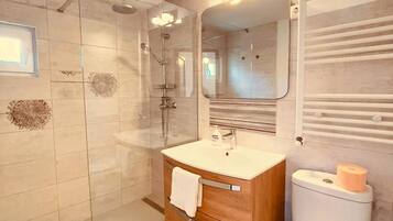 Een douche, handdoeken, zeep, toiletpapier