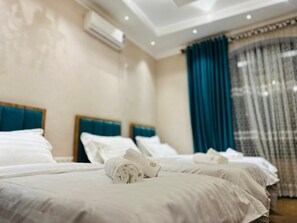 Deluxe driepersoonskamer | Een bureau, een laptopwerkplek, geluiddichte muren, gratis wifi