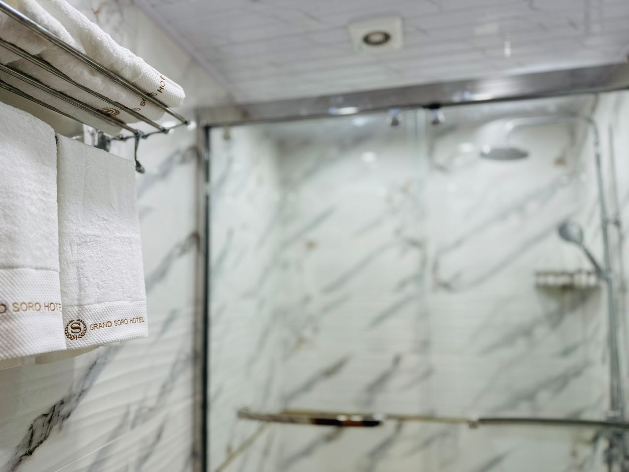 Een badkamer met marmeren wanden en een douchegedeelte.