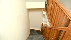 Una escalera con barandillas de madera y peldaños alfombrados.