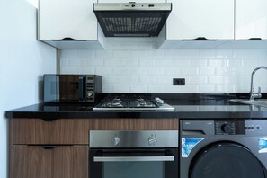 Een koelkast, een oven, een kookplaat, een koffiezetapparaat/waterkoker