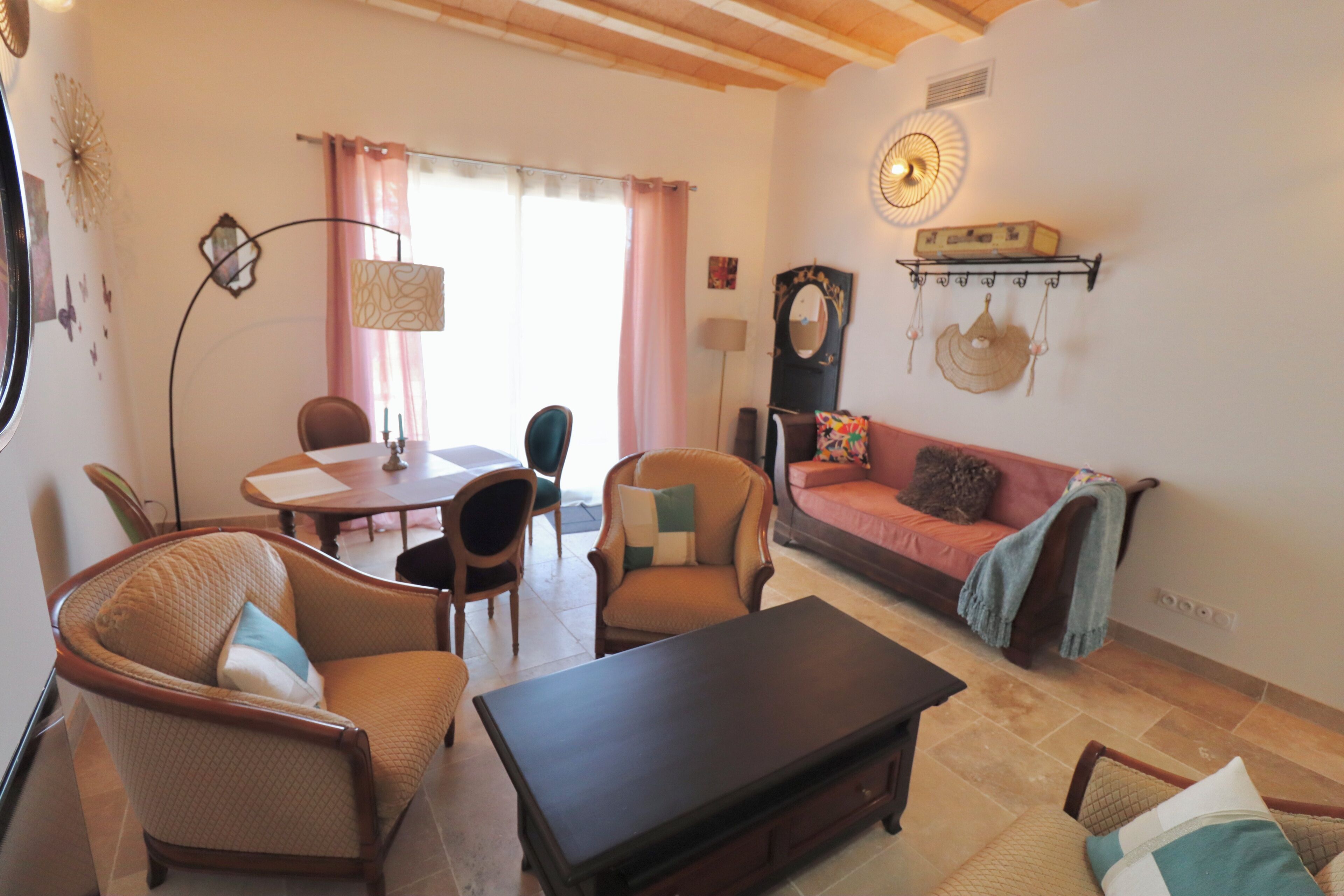 Uma sala de estar com sofá, cadeiras, mesa de centro e mesa de jantar.