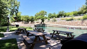 An outdoor area with picnic tables and a swimming pool.