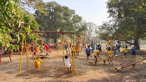 A playground with various play structures including swings, seesaws, and climbing frames. - Green Hills Resort (Vasai)