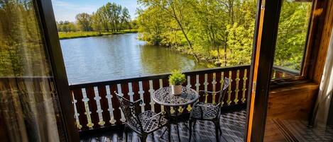A wooden deck with a view of a lake and trees.