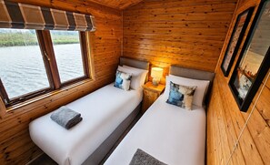 Une cabine avec deux lits, une fenêtre et un intérieur en bois.