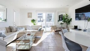 Un salón espacioso con sofá, mesa de centro y comedor con sillas y una mesa.