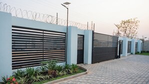 A gated residential area with a paved driveway, metal gates, and a solar street lamp. - F2 - Pool, Inverter, Gym, Pavilion, Wifi, Perfect for Kids - Ibex Meanwood! (Lusaka)