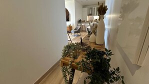 A modern interior with a wooden staircase, a dining area with a table and chairs, and a kitchen in the background. - Superb 3 P with balcony view near beach (Antibes)