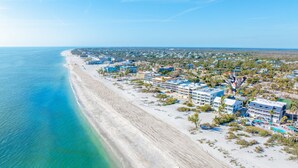 A coastal resort with beachfront properties, a sandy beach, and a clear blue sky. - Your Front Yard? The Gulf of Mexico – Blue Gulf 202 Beachfront Condo (Sanibel)
