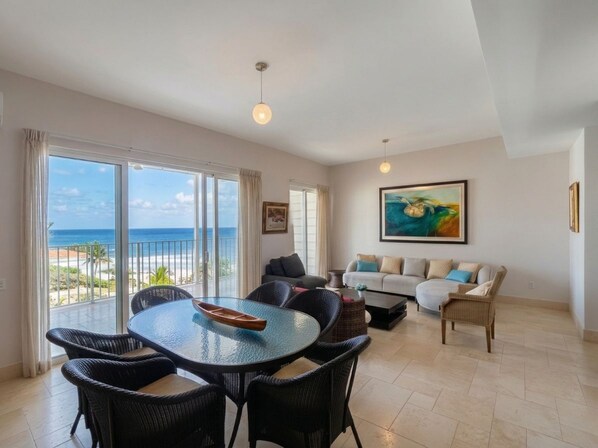 A spacious living area with a balcony, a round table, and a sofa.