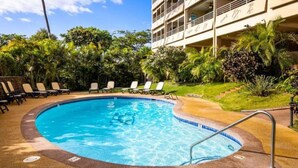 A swimming pool with lounge chairs and a building in the background. - 3 bedrooms 3 baths • Oceans views • Steps to beach (Kihei)