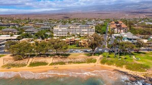 A coastal hotel with multiple buildings, a sandy beach, and clear turquoise waters. - 3 bedrooms 3 baths • Oceans views • Steps to beach (Kihei)