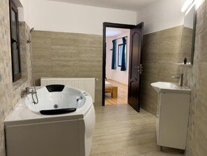 A modern bathroom with a bathtub, a sink, and a mirror. - Pensiunea Poiana Izvoarelor  (Vatra Dornei)