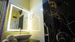 Baño con lavabo, espejo y ducha.