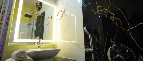 Baño con lavabo, espejo y ducha.