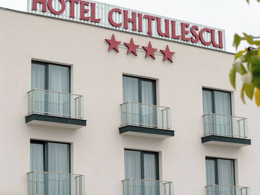 A hotel named "HOTEL CHITULESCU" with a sign featuring three stars and multiple balconies.