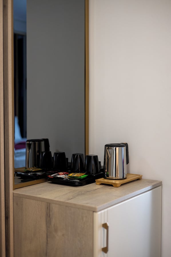 A kitchenette with a coffee maker, a kettle, and a toaster on a wooden countertop. - Chitulescu Hotel (Targoviste)