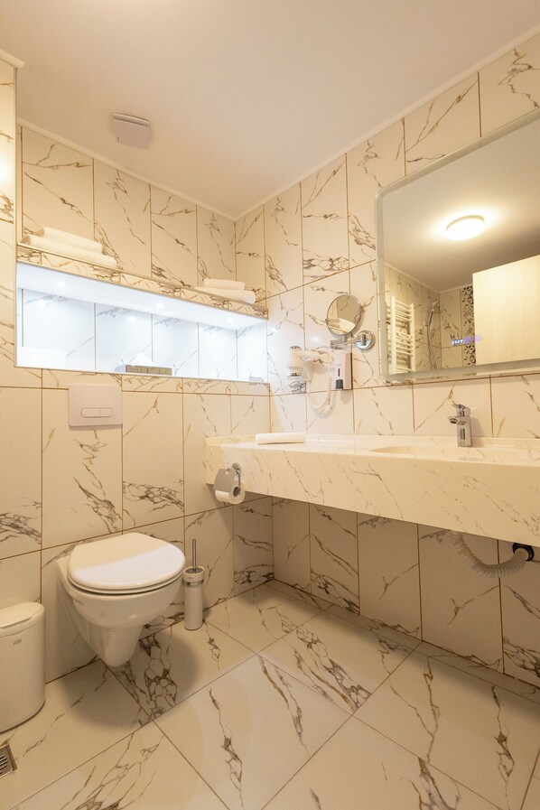 A bathroom with a toilet, sink, and mirror. - Chitulescu Hotel (Targoviste)