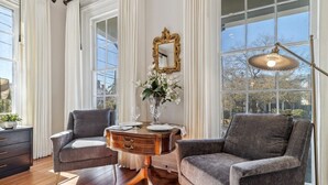 A room with two armchairs, a wooden side table, a mirror, and a lamp. - Palazzo Sul Monte-Uno (Wilmington)