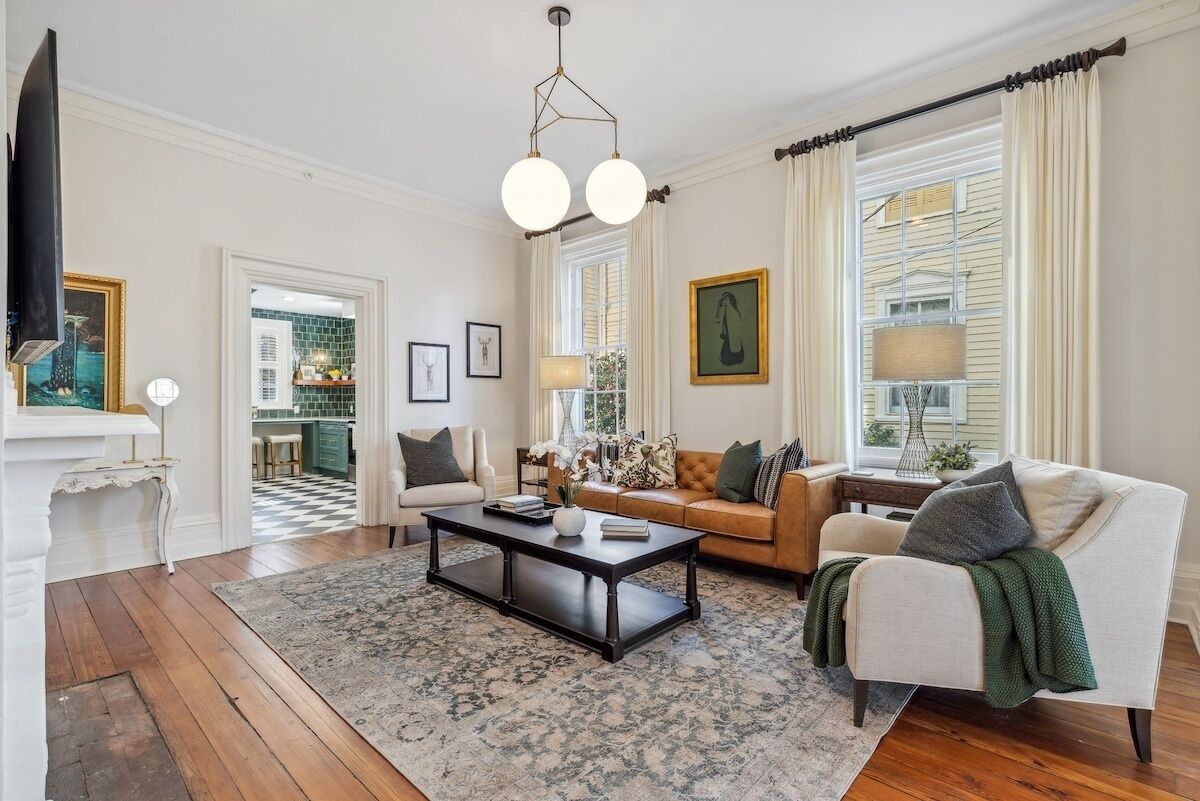 A living room with a wooden floor, a coffee table, a sofa, and a television.