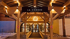 L’entrée de La Cordée est reconnaissable à l’enseigne au-dessus des portes, au lustre et au chemin de pierre qui mène à l’entrée.
