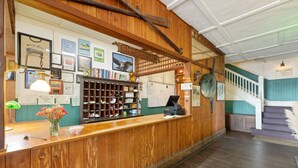A reception desk with a check-out sign, framed certificates, and a shoe display.