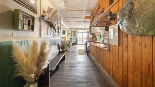 A hallway with wooden walls, a bench, and a wooden floor.