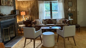 A cozy living room with a fireplace, a sofa set, a coffee table, and a rug. - Retro Cottage Farmstay
Mid-term Comfort for Family Relocations/Professionals (Newton)