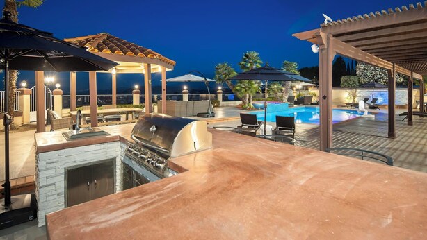 An outdoor patio with a barbecue grill, pool, and covered seating areas. - Scenic Luxury Oasis: Views, Pool, Spa, Game & Movie Rms (Bonita)
