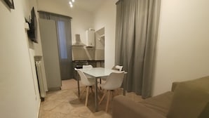A compact living space with a dining area, kitchenette, and seating area. - HH Monferrato (Alessandria)