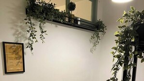 A dining area with a yellow table and black chairs, a small potted plant, and a framed menu on the wall. - KK30 Apartment (Budapest)