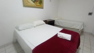 Quarto com uma cama grande, uma cama menor, uma escrivaninha e um quadro na parede.