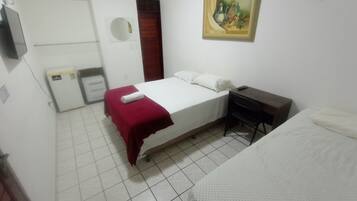 Une chambre à coucher comprenant un lit, un bureau, une chaise, une armoire, un miroir et un tableau accroché au mur.