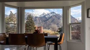 A dining area with a view of snow-capped mountains. - Cottonwood Basecamp-Game Room, 6TVS, Near Canyons! (Sandy)