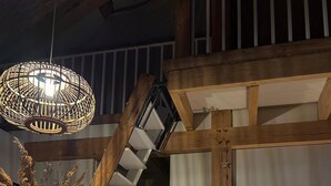 A modern interior with a wooden staircase, a dining area with a round table and chairs, and a hanging light fixture. - Oak Chalet In Zutendaal (Zutendaal)