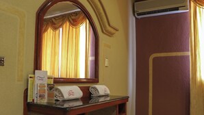 A hotel bathroom with a vanity, a mirror, a towel rack, and a shower area. - Motel Caribe (Córdoba)