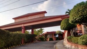 A hotel entrance with a canopy labeled "Hotel Caribe" and a paved road with directional arrows. - Motel Caribe (Córdoba)