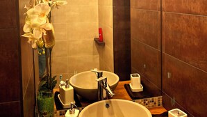 A modern bathroom with two sinks, a large mirror, and a decorative orchid plant. - Apartment with free parking in central Tallinn (Tallinn)