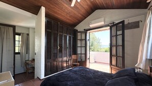 A bedroom with a large bed, wooden ceiling, and a sliding glass door leading to an outdoor area. - Amazing Home in Bella!!!Beautiful views, peace, and everything you need to enjoy (Bella Vista)