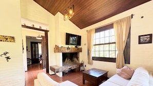 A cozy living room with a fireplace, a sofa, and a television. - Amazing Home in Bella!!!Beautiful views, peace, and everything you need to enjoy (Bella Vista)